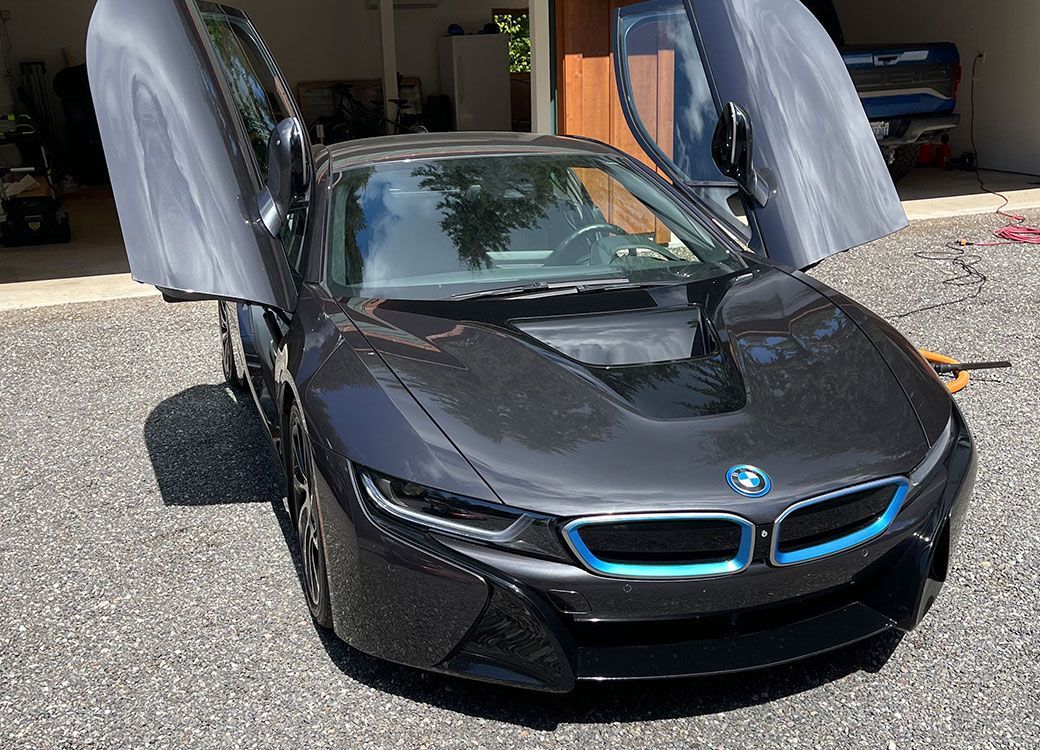 Black BMW i8 with its doors raised, ceramic coated at Custom Details in Portland
